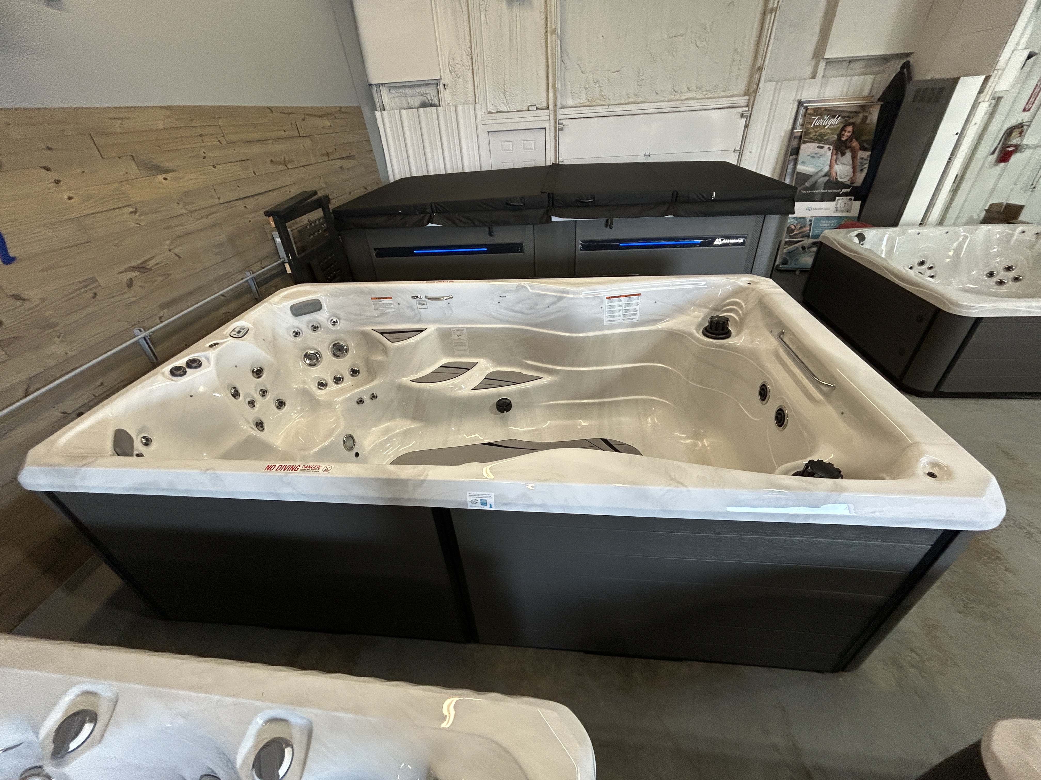 Master Spas Therapool 13 swim spa on a showroom floor at Healthy Living Spas in Mahomet, IL, with 3 seats and 28 jets.