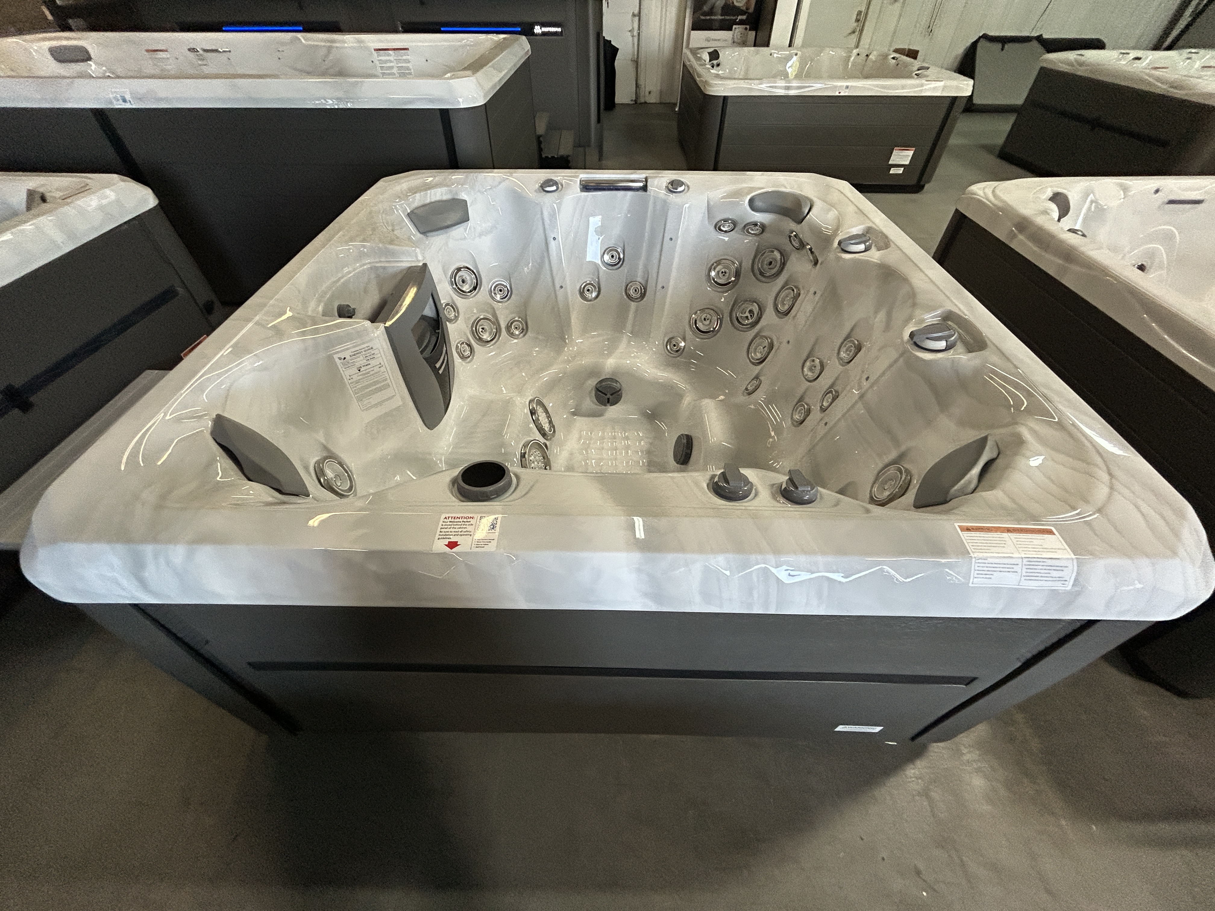 Master Spas TS 7.25 hot tub, sterling silver with a graphite cabinet, shown on a dealer showroom floor in Mahomet, IL.